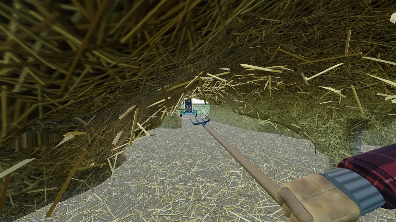 Holding the pitchfork inside a hay tunnel with an Auto-Sifter visible at the far end